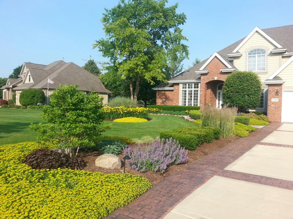 Photo of a medium sized traditional front driveway full sun garden for summer in Chicago with brick paving.