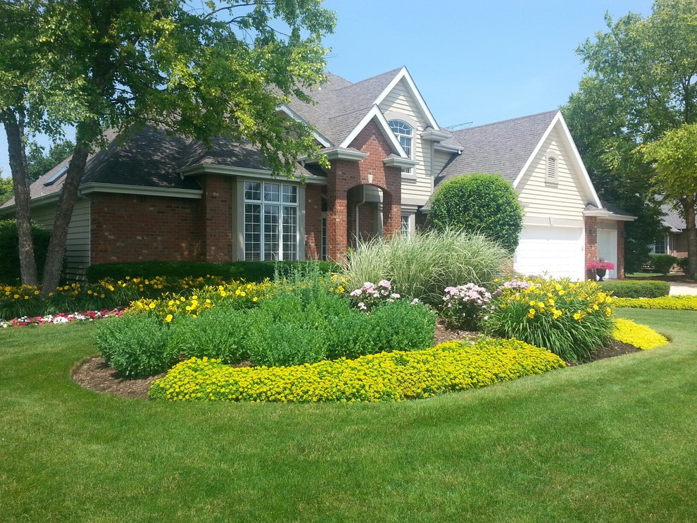 Photo of a mid-sized traditional full sun front yard brick driveway in Chicago for summer.