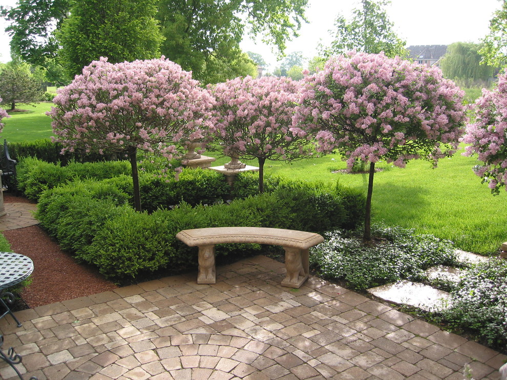 Modelo de jardín clásico en primavera en patio lateral con jardín francés, exposición total al sol y adoquines de piedra natural