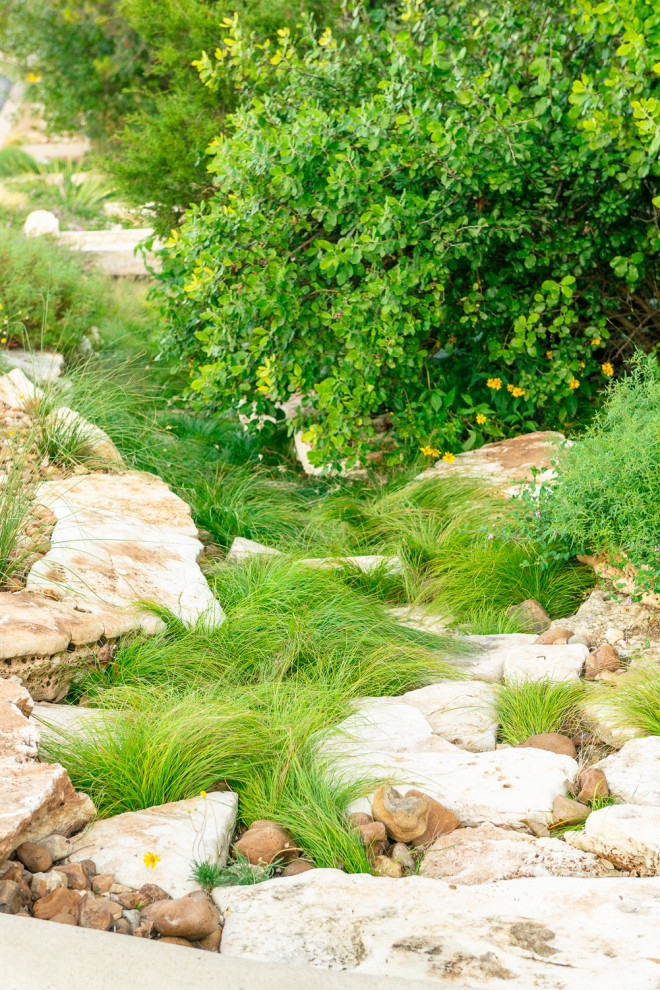 Foto di un ampio giardino stile americano esposto in pieno sole con un pendio, una collina o una riva e sassi di fiume