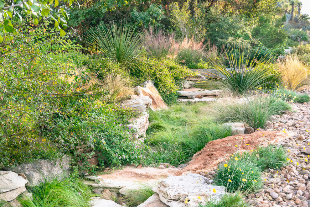 Immagine di un ampio giardino xeriscape american style esposto in pieno sole con un pendio, una collina o una riva e sassi di fiume