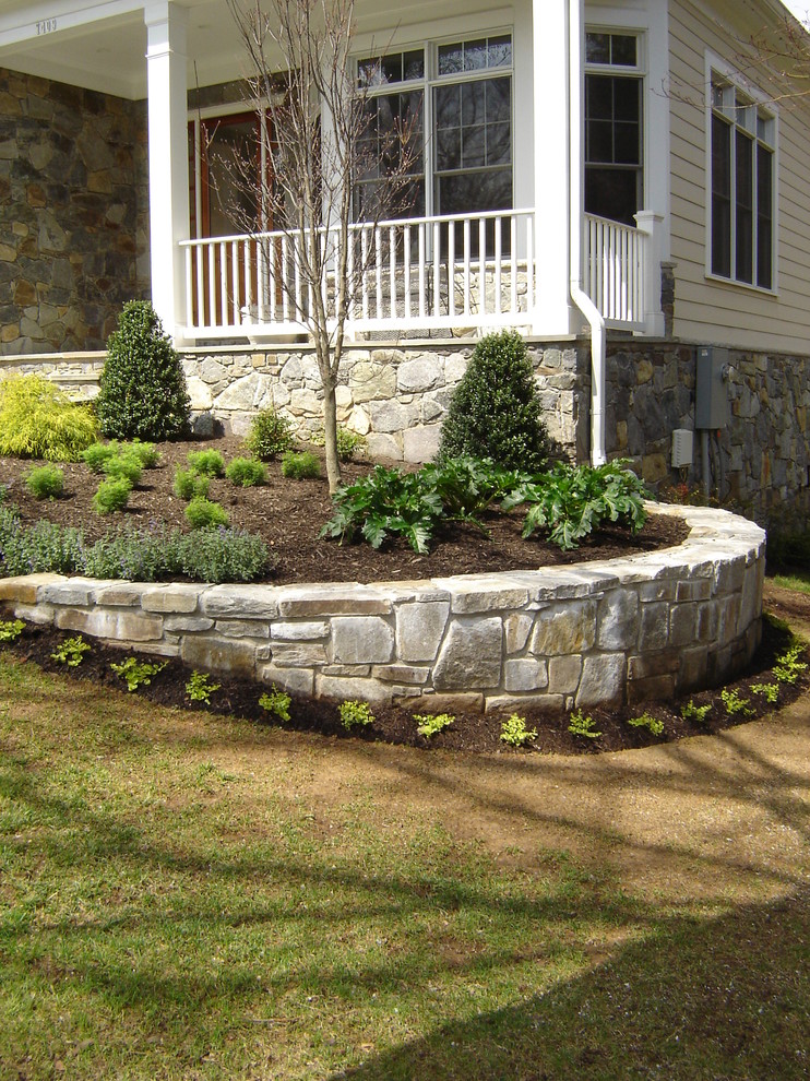 Esempio di un giardino esposto a mezz'ombra di medie dimensioni e davanti casa con un muro di contenimento e pavimentazioni in pietra naturale