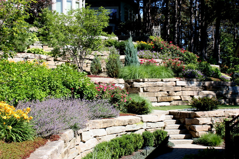 Inspiration for a traditional sloped garden in Detroit with natural stone paving.