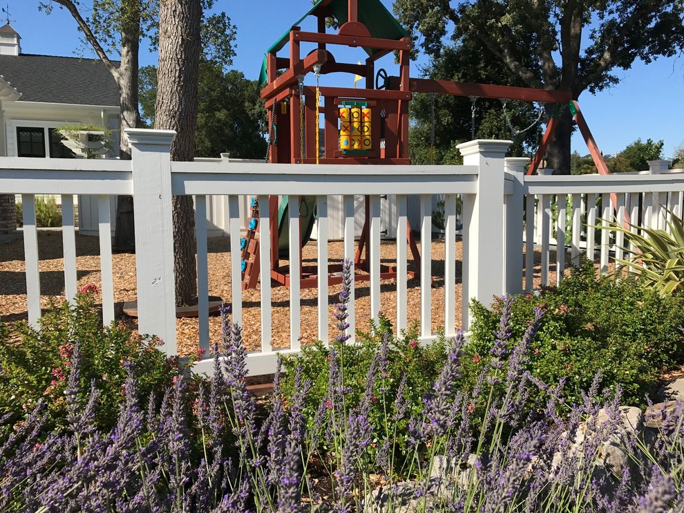 Modelo de jardín clásico grande en patio trasero con parque infantil