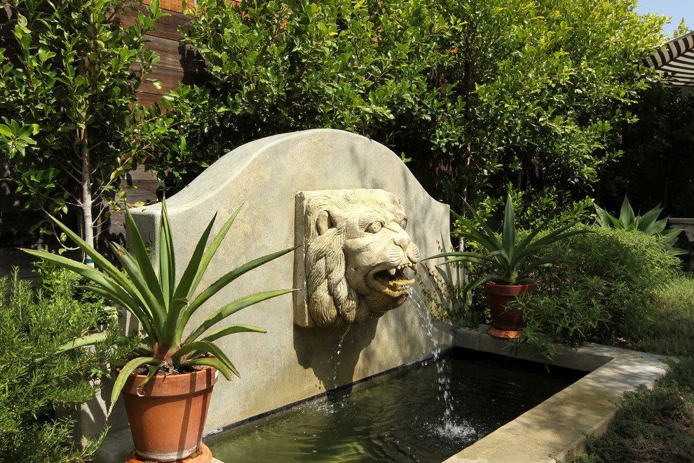 Idee per un grande giardino xeriscape mediterraneo esposto in pieno sole dietro casa in estate con fontane e pavimentazioni in pietra naturale