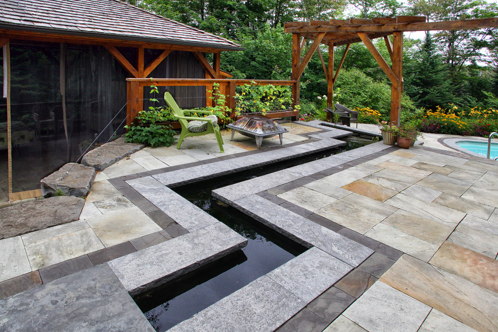 Inspiration pour un jardin à la française latéral chalet l'été avec un point d'eau, une exposition ensoleillée et des pavés en pierre naturelle.