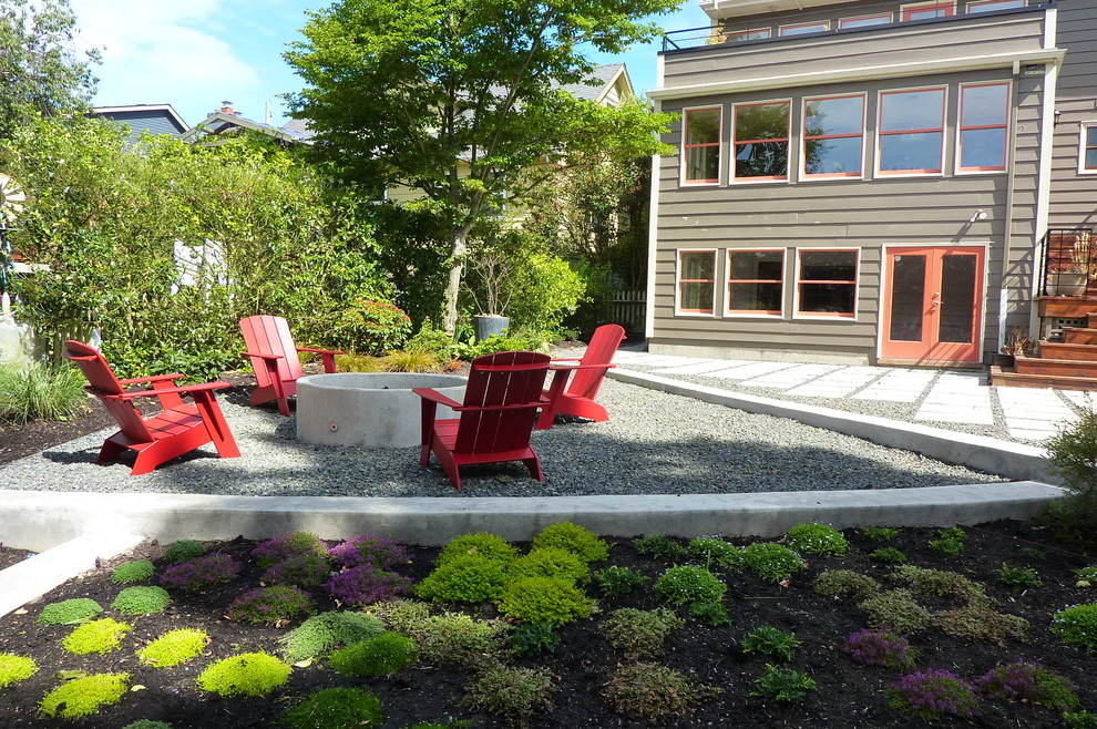 Design ideas for a mid-sized contemporary partial sun backyard gravel landscaping in Seattle with a fire pit for summer.