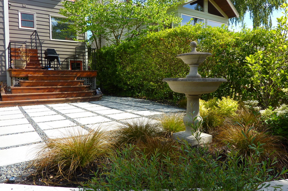 This is an example of a mid-sized contemporary partial sun backyard concrete paver water fountain landscape in Seattle for summer.