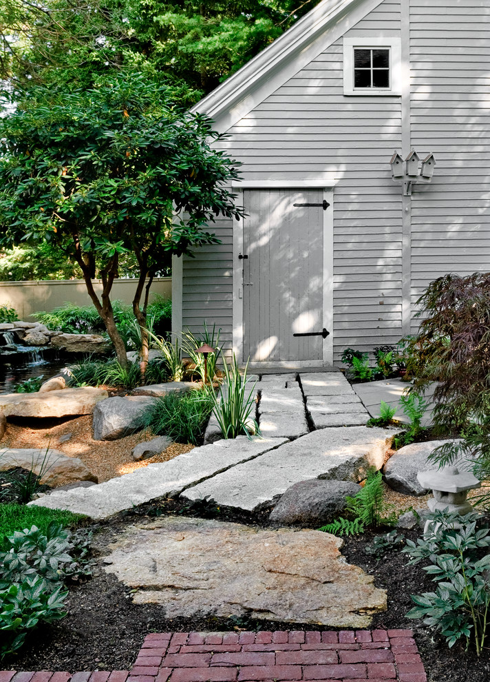 This is an example of a small traditional shade backyard stone water fountain landscape in Portland Maine for winter.