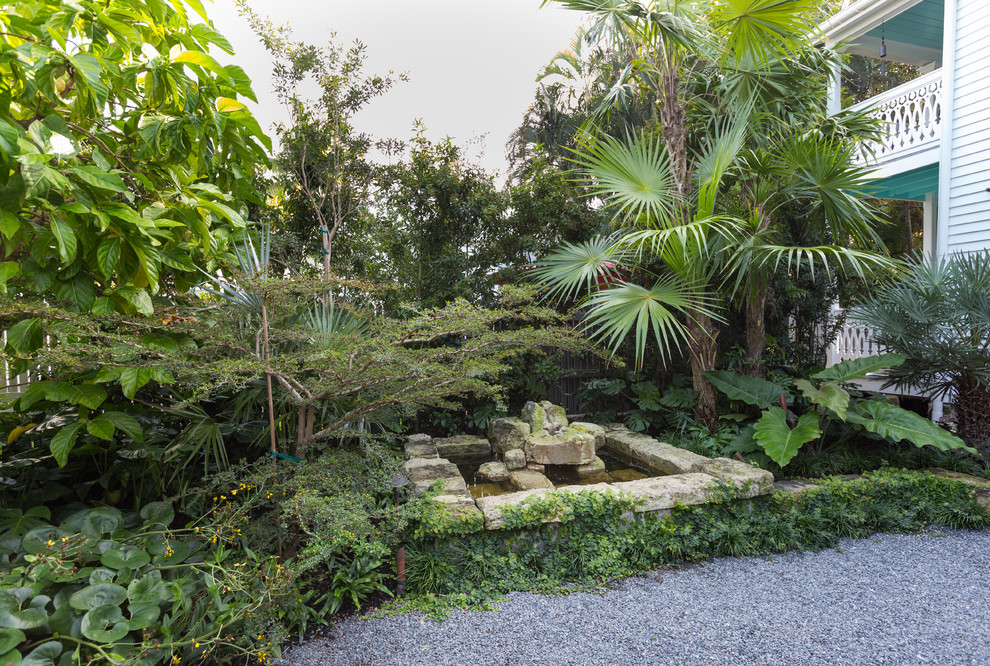 Foto di un piccolo giardino tropicale esposto a mezz'ombra nel cortile laterale con fontane