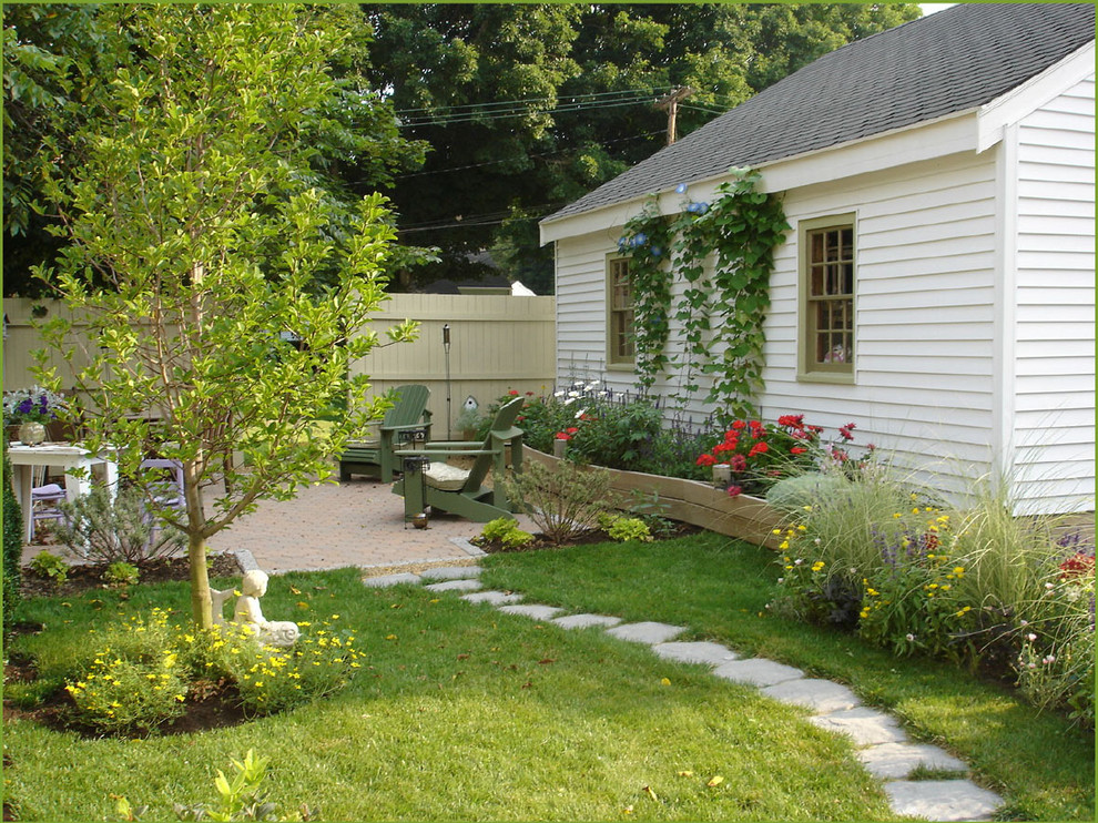 Bild på en liten vintage trädgård i delvis sol på sommaren, med en trädgårdsgång och marksten i betong