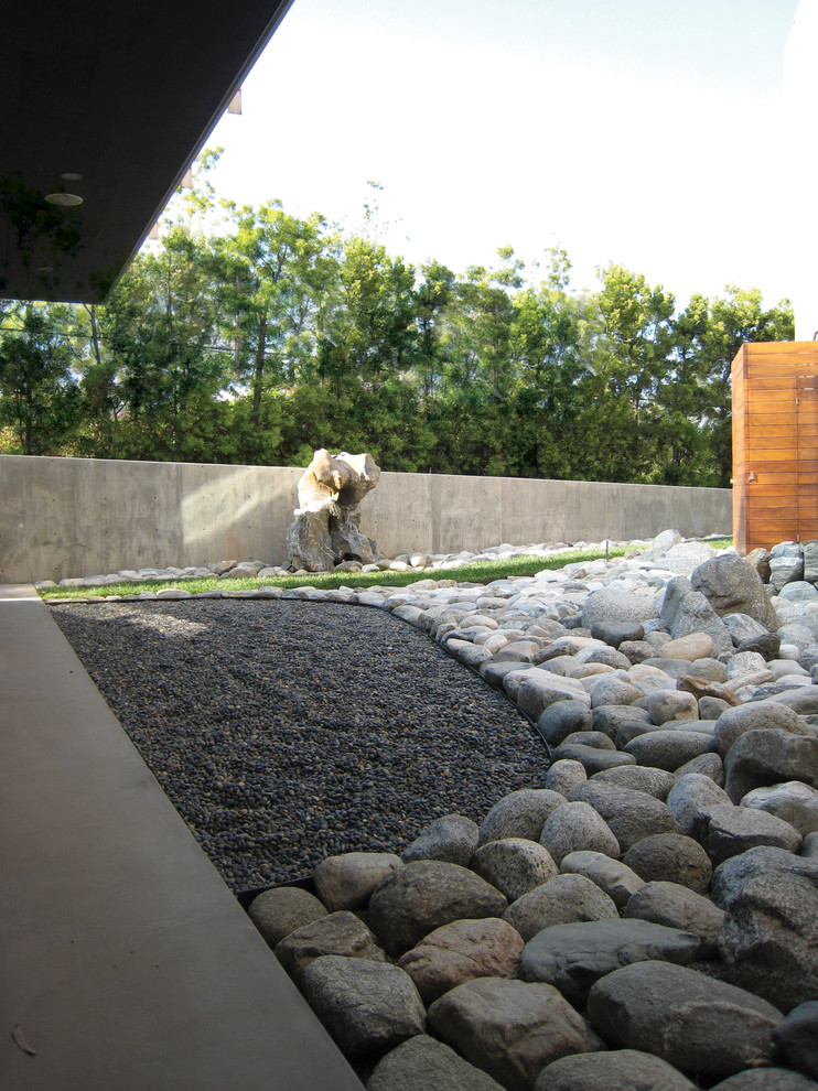 Immagine di un giardino minimalista esposto a mezz'ombra di medie dimensioni e in cortile in primavera con fontane e ghiaia