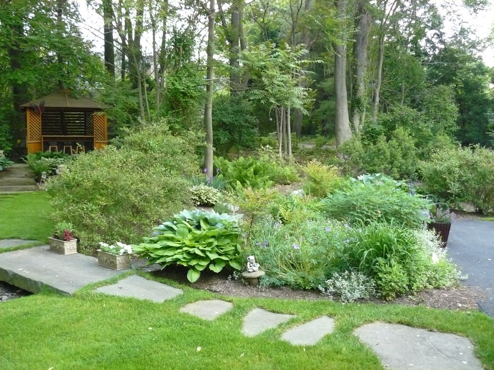Aménagement d'un jardin éclectique avec une exposition ombragée et des pavés en pierre naturelle.