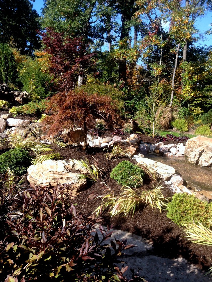 Idee per un grande giardino formale chic esposto a mezz'ombra dietro casa in autunno con pavimentazioni in pietra naturale