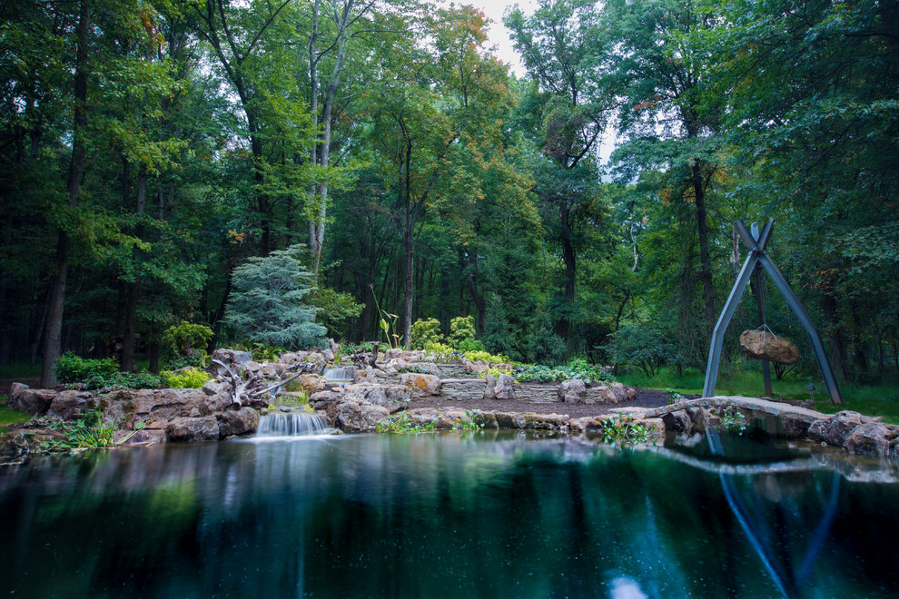 Aménagement d'un grand jardin arrière contemporain l'été avec un bassin et une exposition partiellement ombragée.