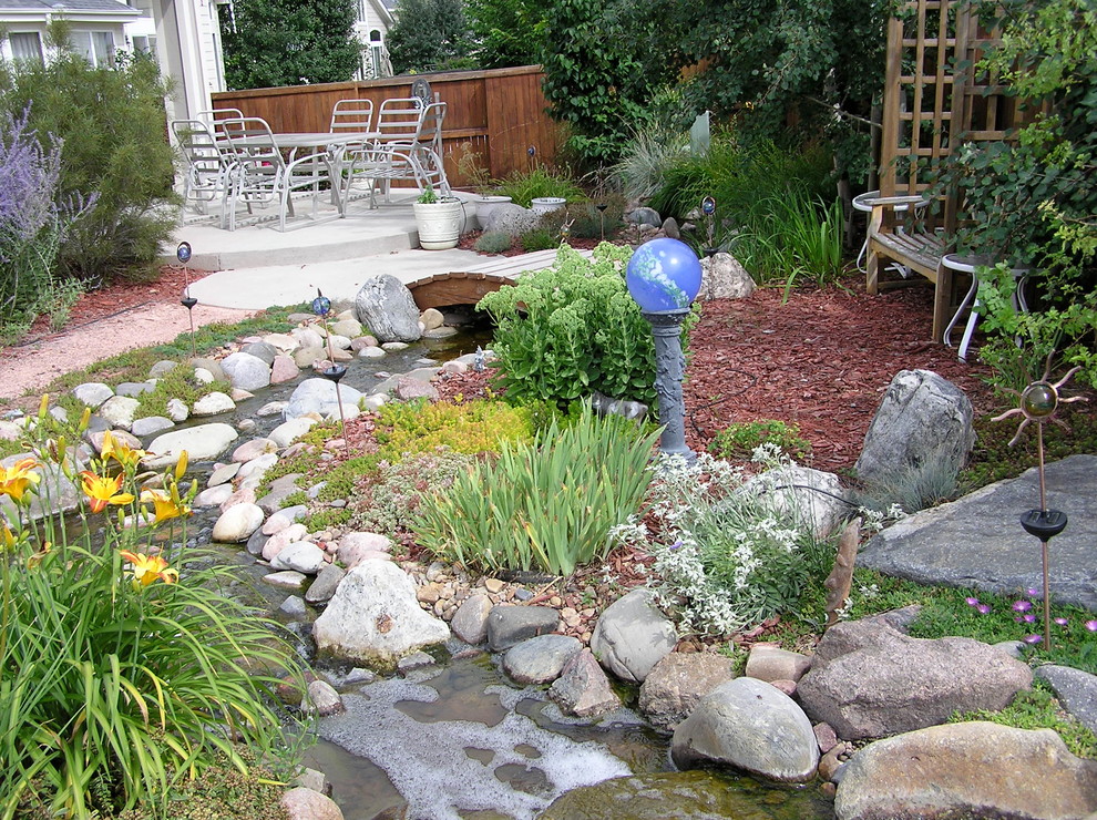 Diseño de jardín tradicional en patio trasero con fuente