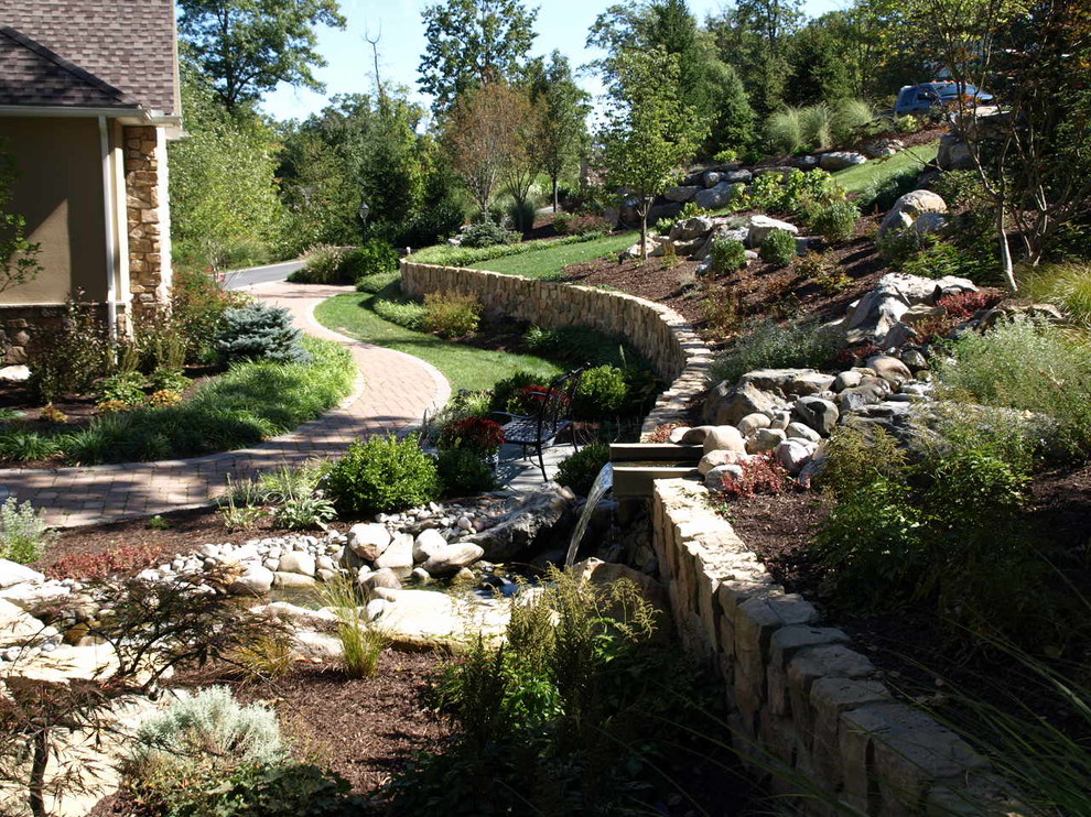 This is an example of a mid-sized traditional full sun courtyard stone water fountain landscape in Philadelphia for summer.