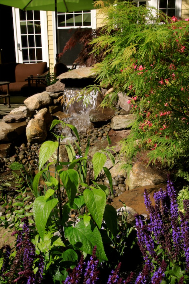 Design ideas for a modern back partial sun garden for summer in Boston with a water feature.
