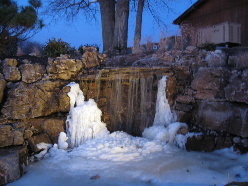 Exemple d'un grand jardin montagne l'hiver avec un point d'eau, une exposition ensoleillée, une pente, une colline ou un talus et des pavés en pierre naturelle.