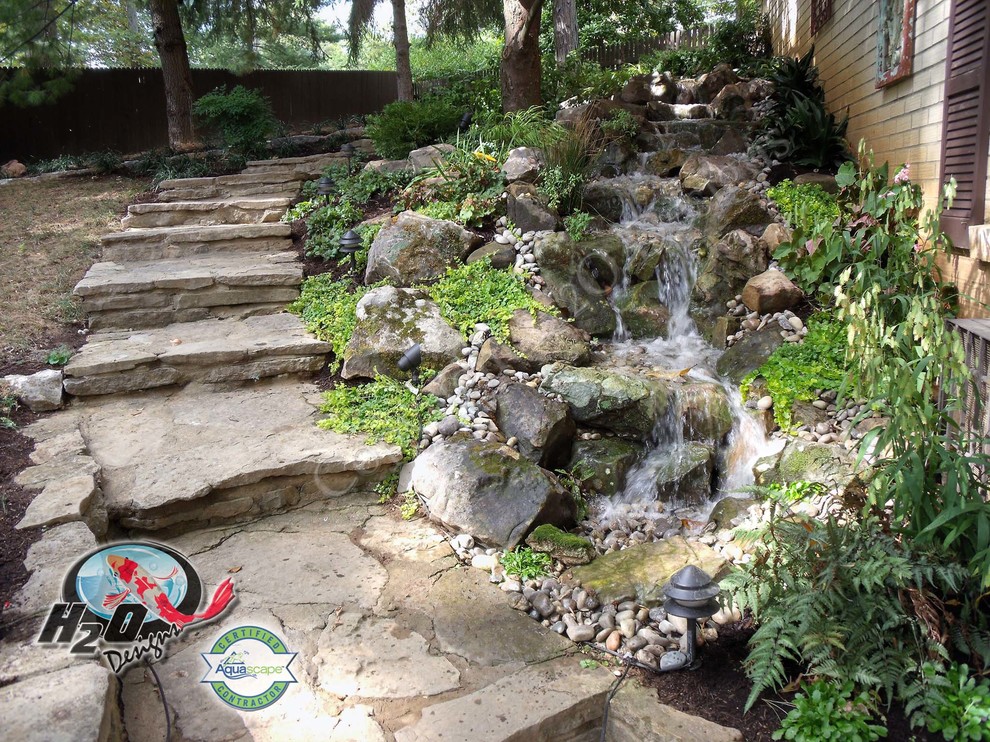 Cette image montre un grand jardin arrière bohème avec un point d'eau et des pavés en pierre naturelle.