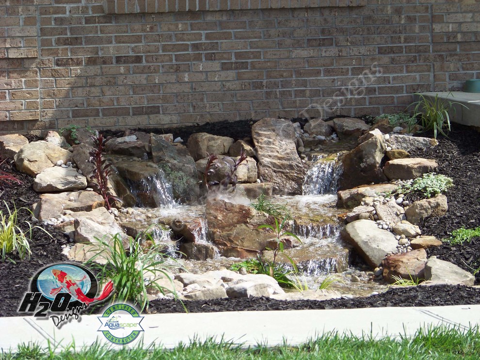 This is an example of a large eclectic partial sun backyard concrete paver water fountain landscape in Louisville.