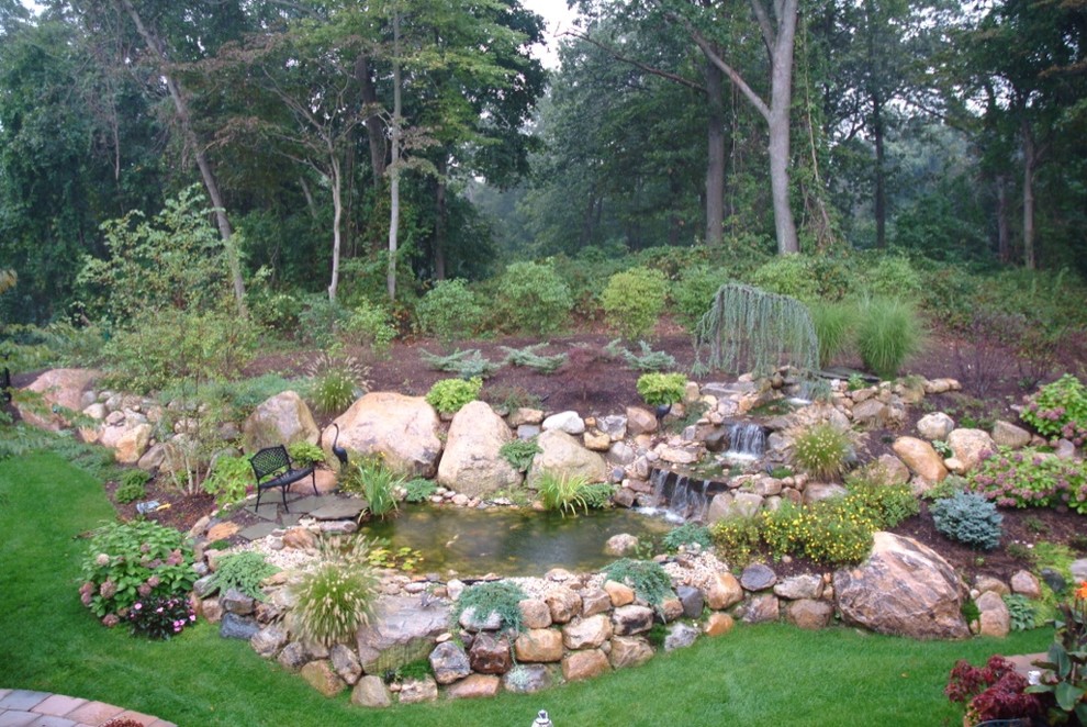 Immagine di un giardino tropicale esposto in pieno sole in estate con un pendio, una collina o una riva e pavimentazioni in pietra naturale
