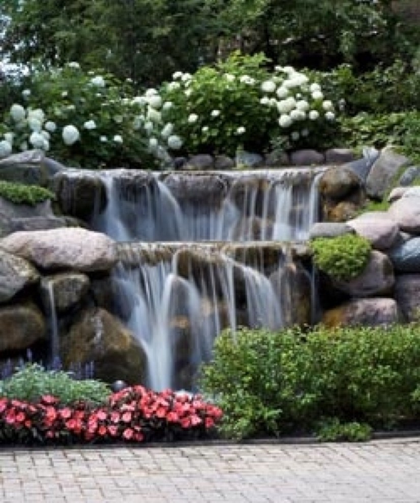 Cette image montre un jardin à la française ethnique l'été avec un bassin, une exposition ensoleillée, une pente, une colline ou un talus et des pavés en pierre naturelle.