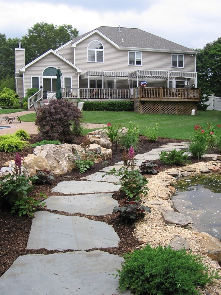 Inspiration for a world-inspired side xeriscape full sun garden for summer in New York with a pond and natural stone paving.