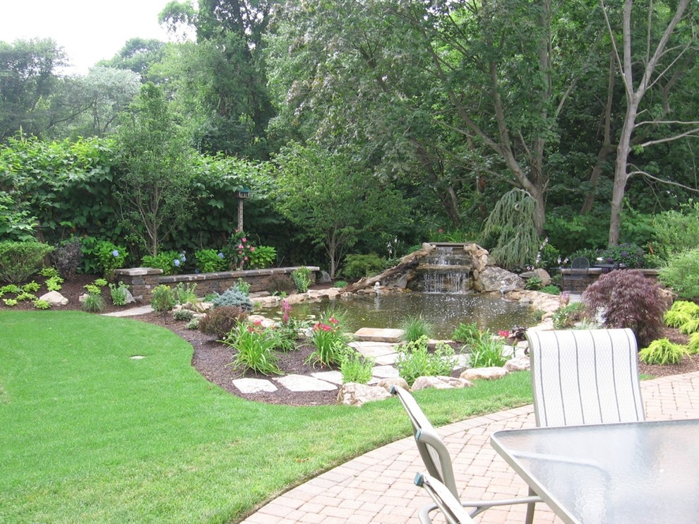 Photo of a tropical drought-tolerant and partial sun side yard stone pond in New York for summer.