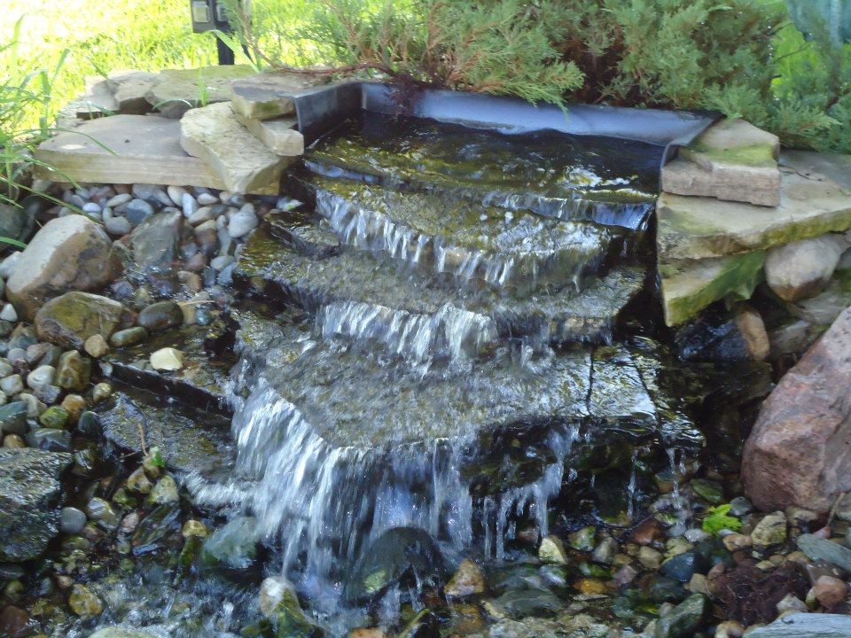 Design ideas for a mid-sized backyard stone water fountain landscape in Detroit.