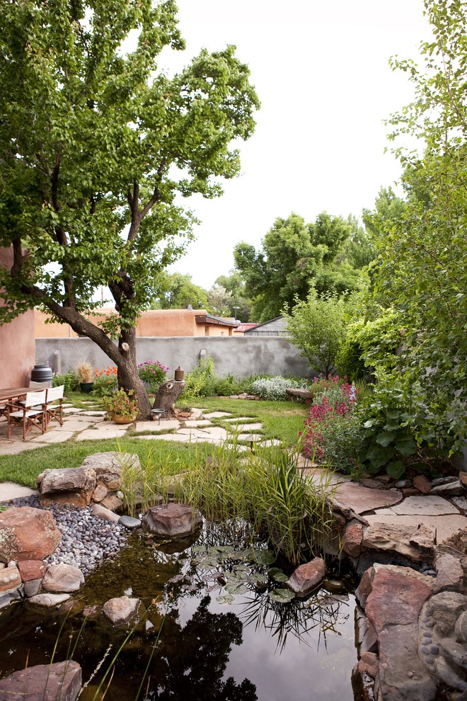 На фото: большой сад с прудом на заднем дворе в классическом стиле с полуденной тенью и покрытием из каменной брусчатки с