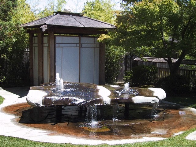 На фото: солнечный садовый фонтан среднего размера на боковом дворе в восточном стиле с хорошей освещенностью и мощением тротуарной плиткой с