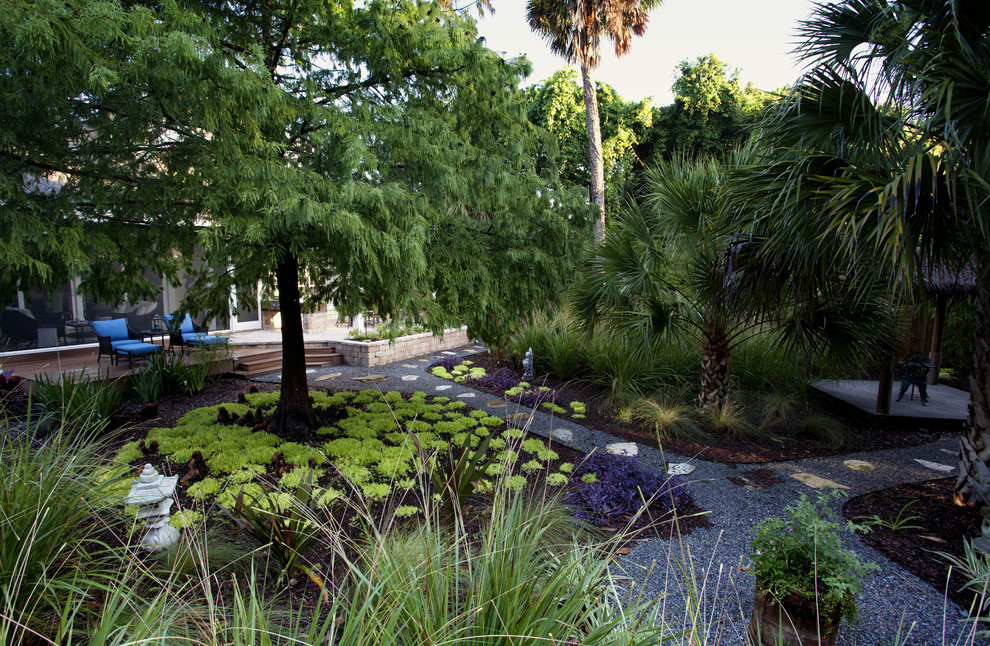 Ispirazione per un giardino tropicale esposto a mezz'ombra di medie dimensioni e dietro casa con ghiaia