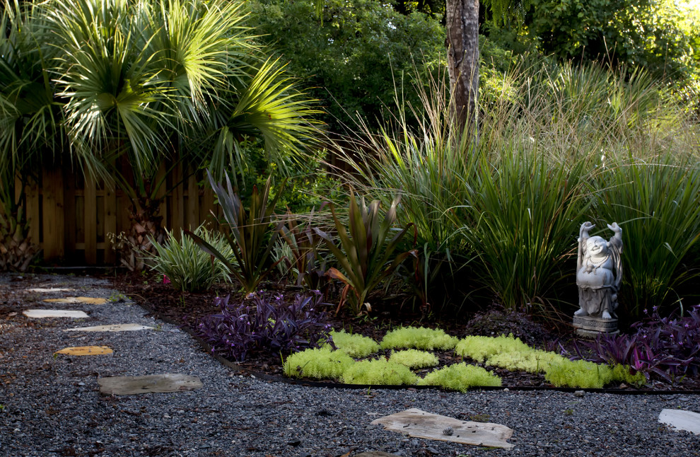 Design ideas for a mid-sized tropical partial sun backyard gravel landscaping in Jacksonville.