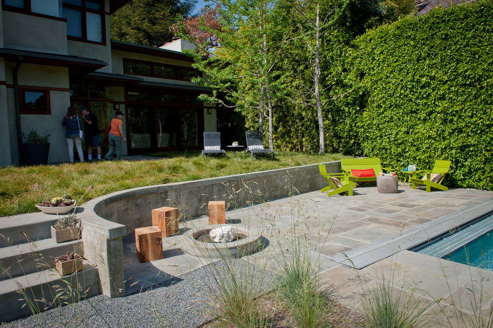 Imagen de jardín de secano moderno grande en primavera en patio trasero con brasero, exposición parcial al sol y gravilla