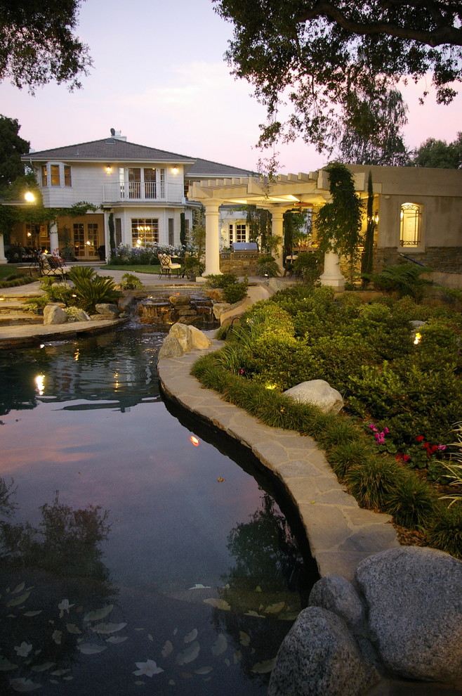Großer Klassischer Garten hinter dem Haus, im Sommer mit Wasserspiel und direkter Sonneneinstrahlung in Los Angeles