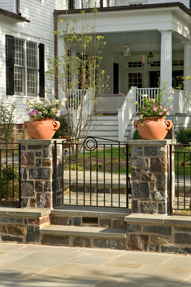 Foto di un grande giardino formale classico esposto in pieno sole dietro casa in estate con un giardino in vaso e pavimentazioni in pietra naturale