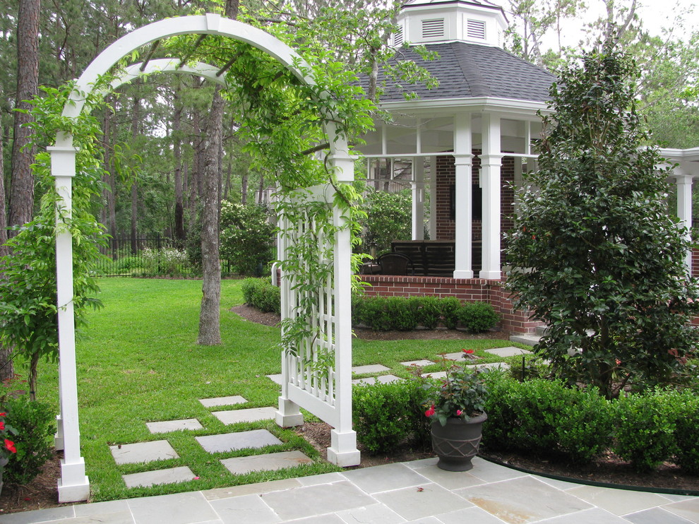 Klassischer Garten hinter dem Haus mit Natursteinplatten in Houston