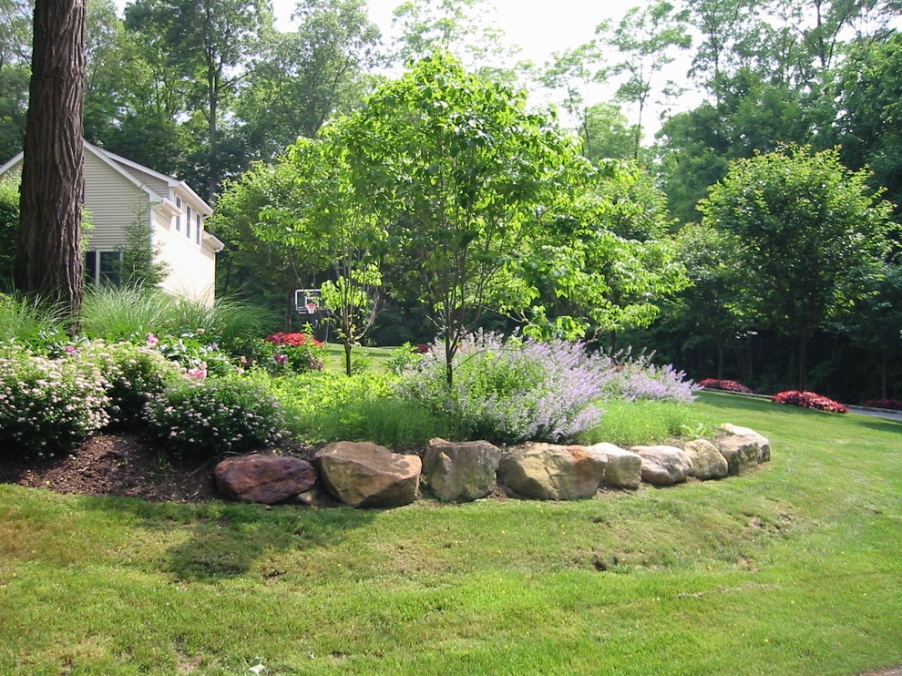Idées déco pour un jardin arrière classique de taille moyenne et au printemps avec une exposition partiellement ombragée et des pavés en pierre naturelle.