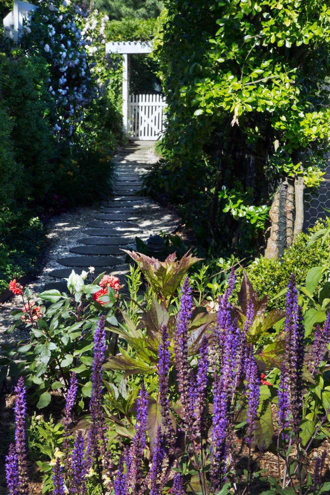 Exemple d'un grand jardin arrière victorien avec une exposition ensoleillée et des pavés en pierre naturelle.