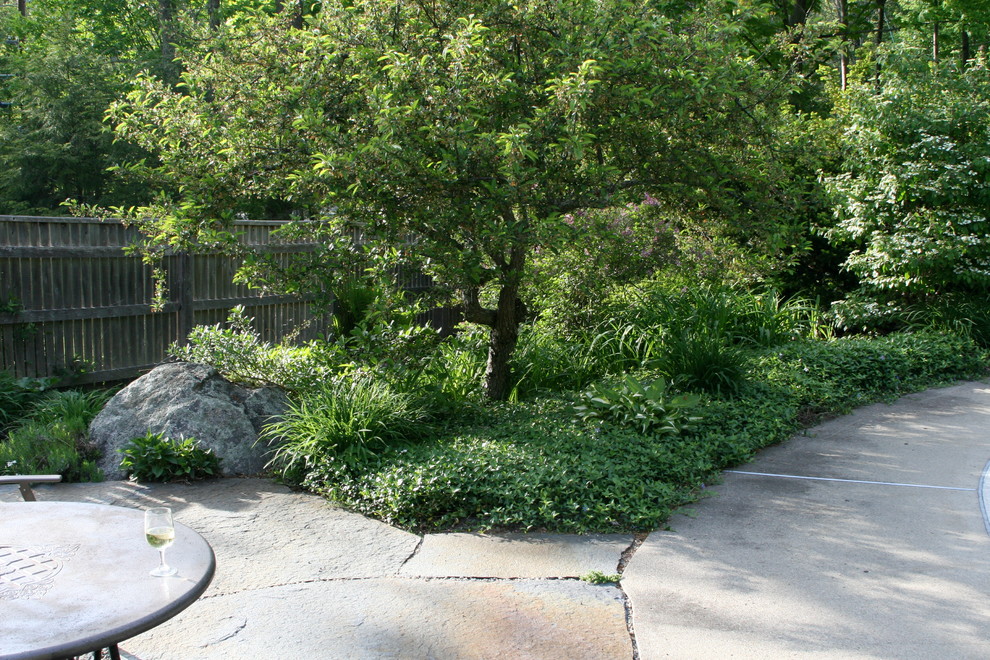 На фото: большой участок и сад на заднем дворе в классическом стиле с покрытием из каменной брусчатки и полуденной тенью с