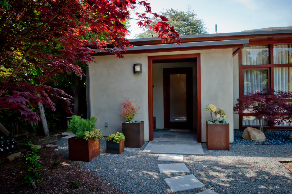 Réalisation d'un jardin arrière minimaliste avec une exposition ombragée et des pavés en béton.