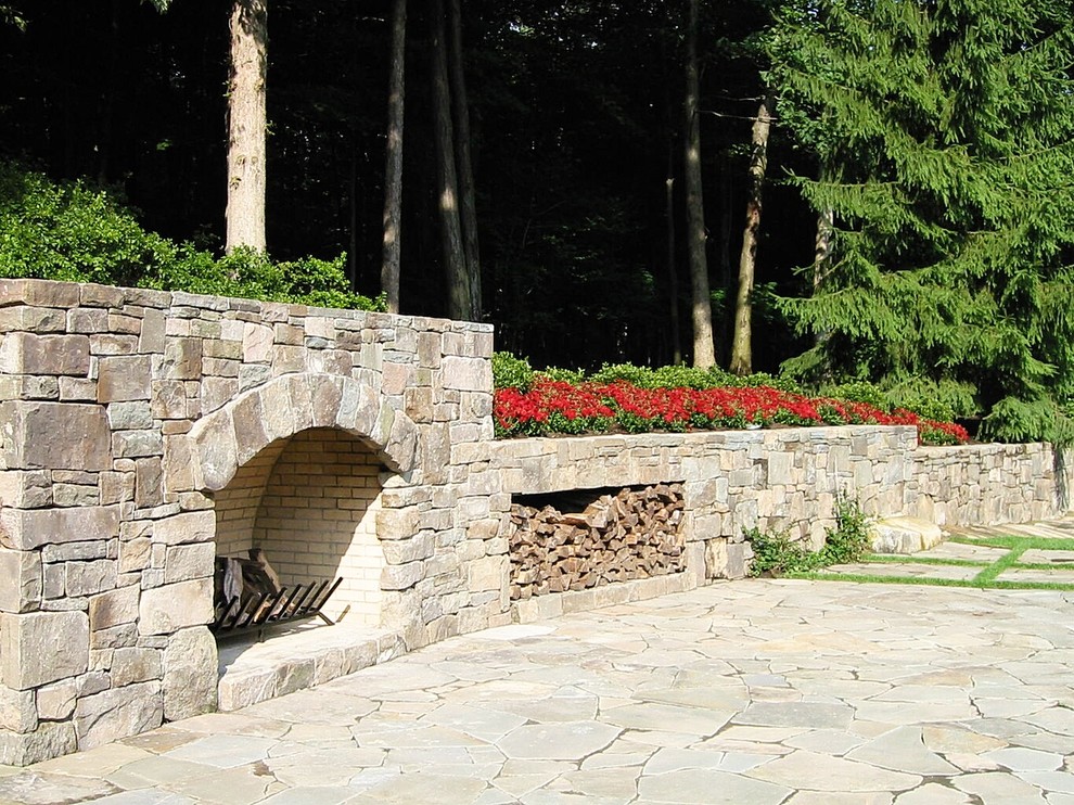 Immagine di un grande giardino formale chic esposto in pieno sole dietro casa in primavera con un muro di contenimento e pavimentazioni in pietra naturale