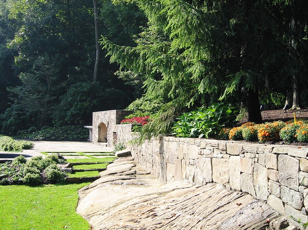 Источник вдохновения для домашнего уюта: большой солнечный, весенний регулярный сад на заднем дворе в классическом стиле с подпорной стенкой, хорошей освещенностью и покрытием из каменной брусчатки