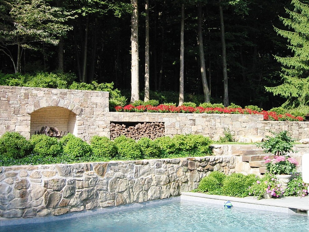 На фото: большой солнечный, весенний регулярный сад на заднем дворе в классическом стиле с подпорной стенкой, хорошей освещенностью и покрытием из каменной брусчатки с
