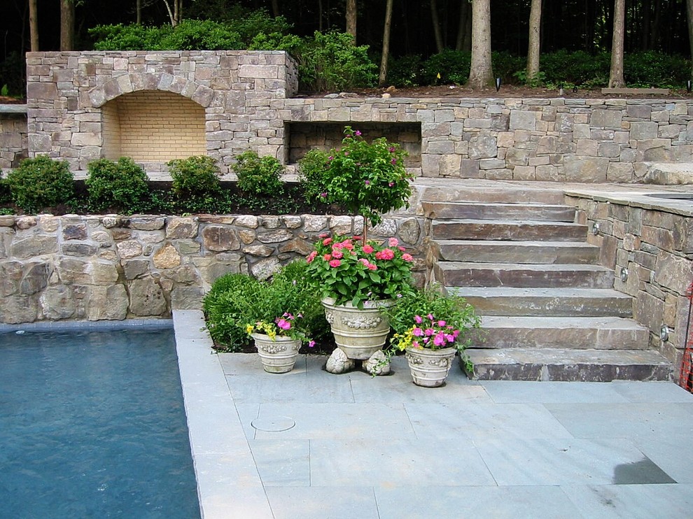 Esempio di un grande giardino formale chic esposto in pieno sole dietro casa in primavera con un muro di contenimento e pavimentazioni in pietra naturale