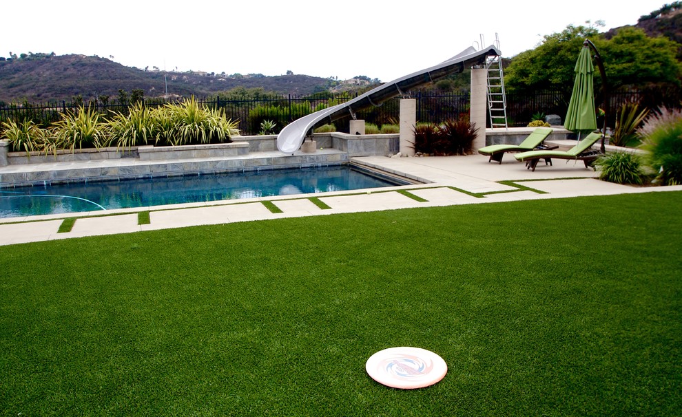 Photo of a large modern full sun backyard concrete paver water fountain landscape in San Diego for summer.