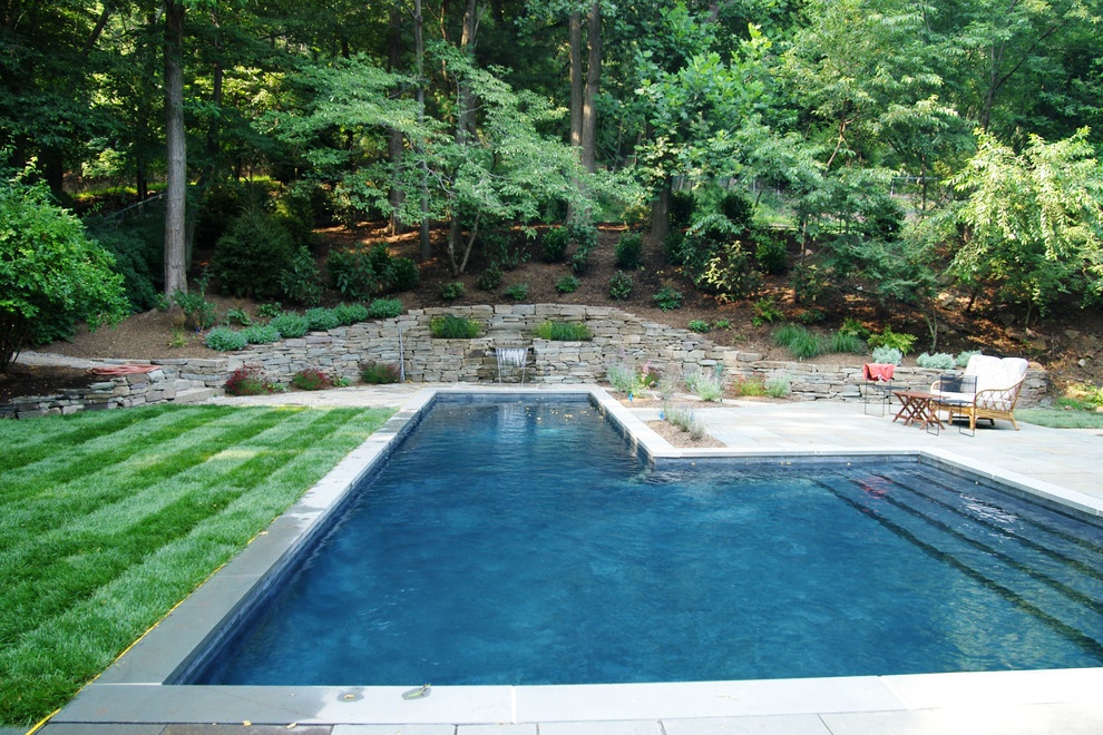 This is an example of a large traditional backyard stone landscaping in New York.