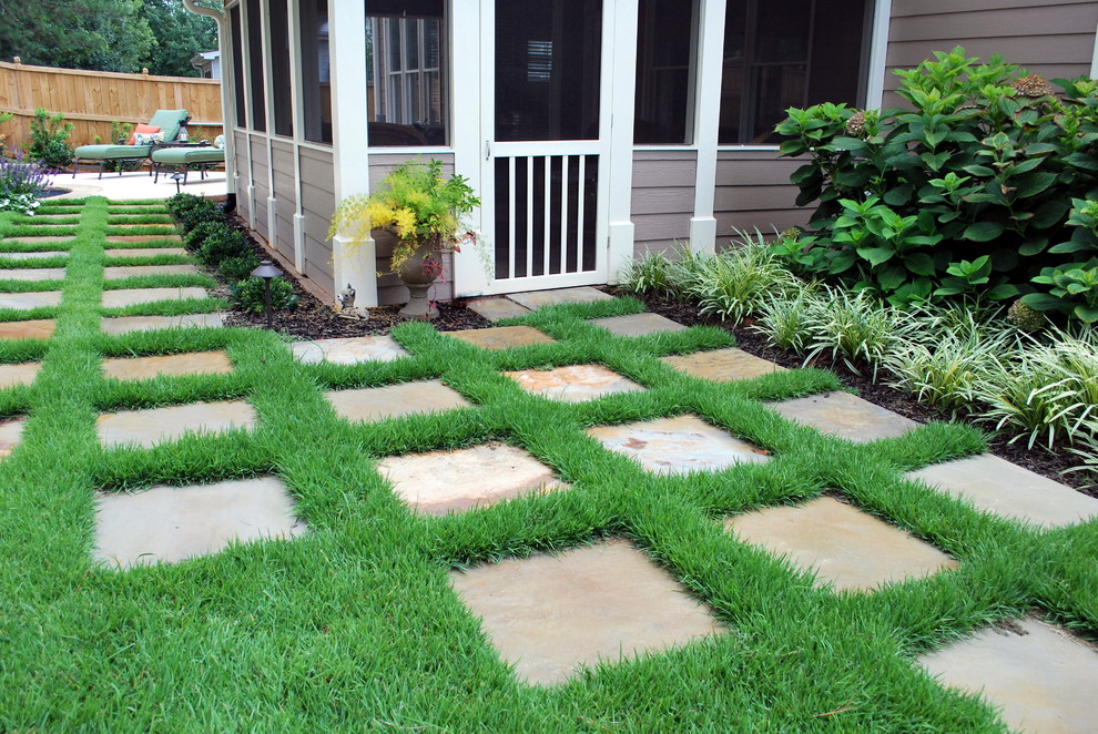 This is an example of a mid-sized traditional partial sun backyard stone landscaping in Atlanta for summer.
