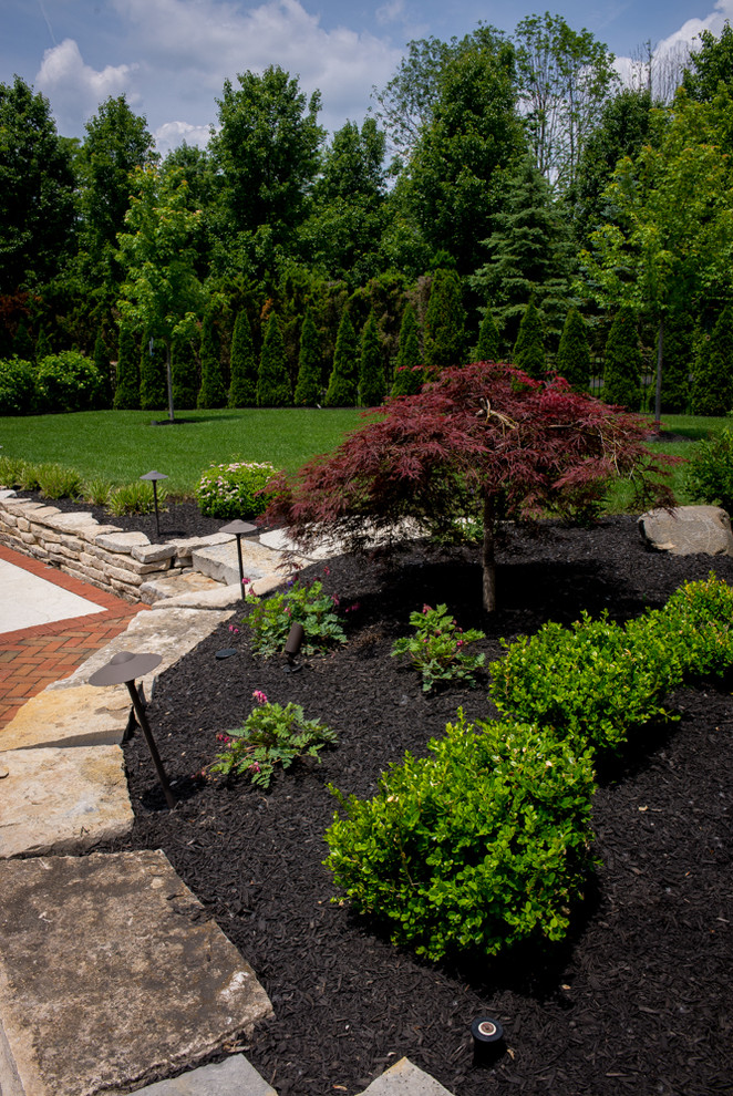 На фото: большой солнечный участок и сад на заднем дворе в классическом стиле с дорожками, хорошей освещенностью и мощением клинкерной брусчаткой
